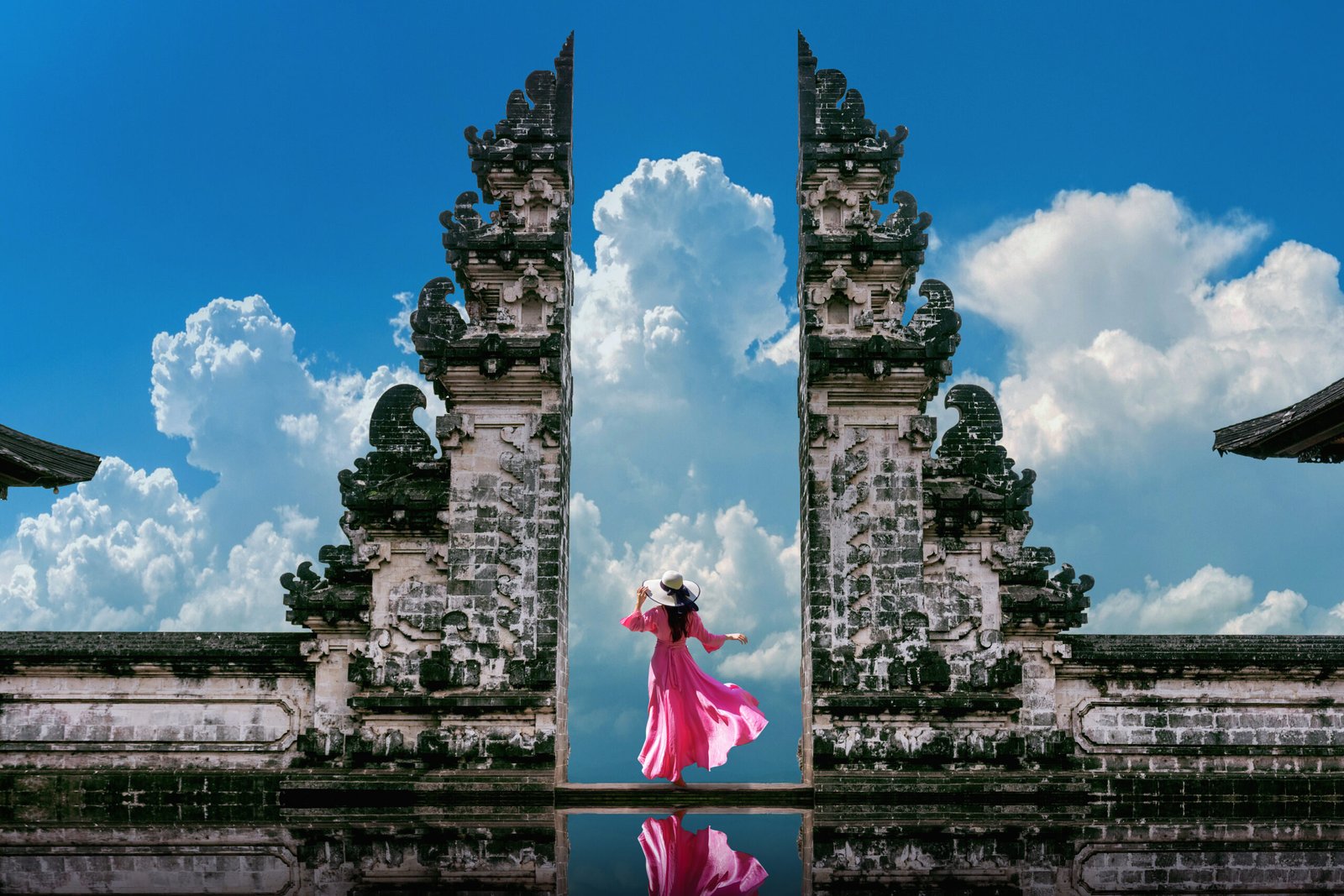 Young woman standing in temple gates at Lempuyang Luhur temple i