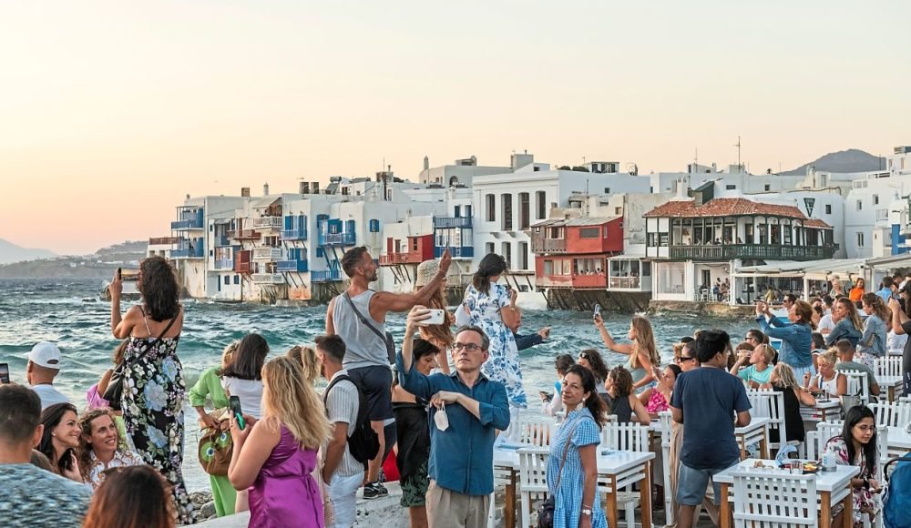 FILE — Crowds gathering for the sunset in Mykonos, Greece, on Aug. 7, 2022. As development alters Greek islands’ nature and culture, the locals push back. (Maria Mavropoulou/The New York Times)