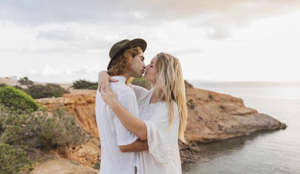 Kissing young couple in love in front of the sea, Ibiza, Balearic Islands, Spain