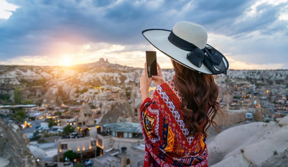 Woman take a photo with her smartphone at Goreme, Cappadocia in Turkey.